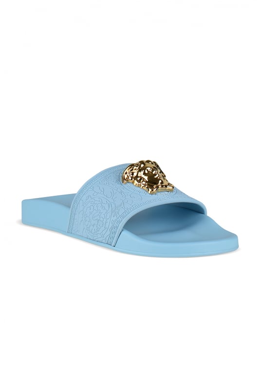 Medusa Versace-slippers van hemelsblauw rubber.Medusa-verfraaide band van goudkleurig metaal met reliëf.Platte rubberen zool.Gemaakt in Italië.