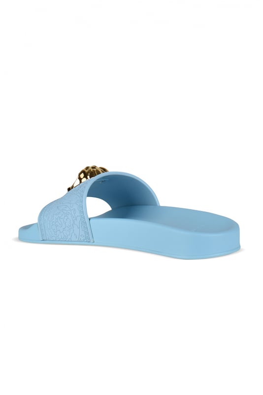 Medusa Versace-slippers van hemelsblauw rubber.Medusa-verfraaide band van goudkleurig metaal met reliëf.Platte rubberen zool.Gemaakt in Italië.