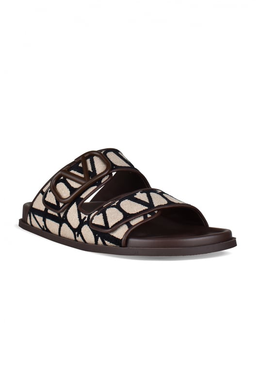 Sandalias Valentino de piel marrón.Lona iconográfica beige con logo monograma negro.Ribete marrón con logotipo V de la firma.Cierre de velcro delantero.Suela de goma.Made in Italy.