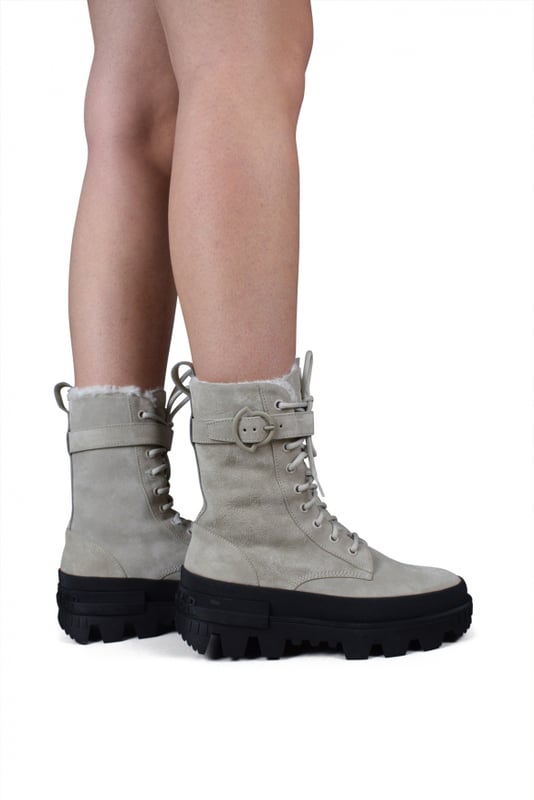 Moncler-laarzen, Carinne-model in beige suède.Enkelriempje.Voering van imitatiebont.Vetersluiting.Strapje op de hiel met Moncler-opschrift.Zwarte ingekeepte zool met rubberen logo.100% leer.Gemaakt in Italië.