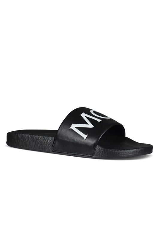 Moncler muiltjes zwart Zwarte Moncler-slippers.Wit logo op de zwartleren tong.Zwarte rubberen zool.Gemaakt in Italië.