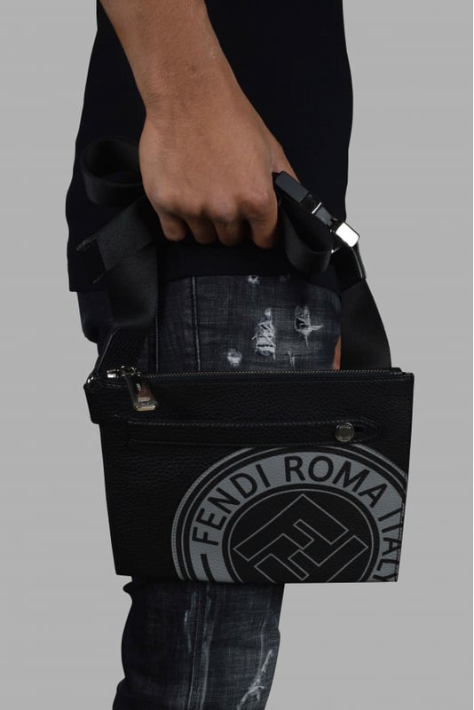 Bolso de mano de Fendi en piel de becerro negra granulada.Logotipo gris impreso en la parte delantera.Asa de cuero con botón de metal.Correa de tela ajustable para el hombro.Cierre de cremallera con lengüeta plateada.Placa interior con el logotipo.Bolsillo interior con cremallera.Tamaño: 19 cm x 23,5 cm.Made in Italy.