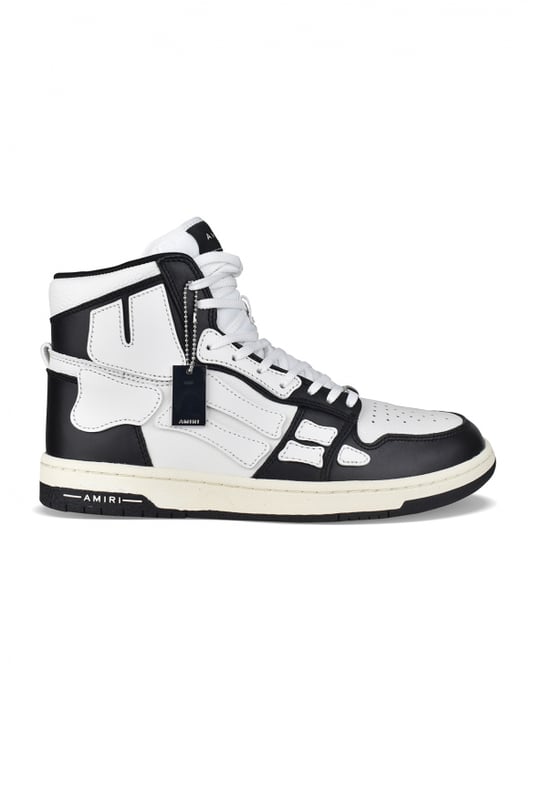 Sneakers altas Skel Top Amiri de piel negra y blanca.Inserciones de cuero blanco formando un esqueleto.Lengüeta de nailon blanco con logotipo.Placa metálica con el logotipo en la parte delantera.Suela fina de goma negra y blanca con logotipo.Cordones blancos.Puntera redonda.