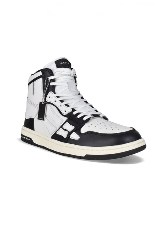 Sneakers altas Skel Top Amiri de piel negra y blanca.Inserciones de cuero blanco formando un esqueleto.Lengüeta de nailon blanco con logotipo.Placa metálica con el logotipo en la parte delantera.Suela fina de goma negra y blanca con logotipo.Cordones blancos.Puntera redonda.