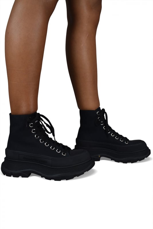 Sneakers altas Alexander McQueen Tread Slick.Lona negra.Puntera redonda con inserción de goma.Logotipo en el talón y la lengüeta.Cierre de cordón plano negro.Suela de goma negra sobredimensionada con la firma.Made in Italy.