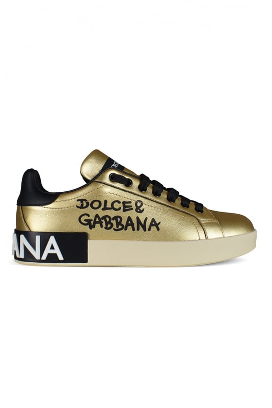 Dolce&Gabbana Portofino Sneakers aus goldfarbenem Leder.Schwarzer Dolce&Gabbana-Schriftzug auf die Seite gedruckt.Kontrastierende Fersenkappe aus schwarzem Leder.Flache schwarze Schnürsenkel.Innensohle aus Leder mit Logoetikett.Logo-Außensohle aus Gummi mit schwarzem Einsatz aus Lamé-Leder und weißem, mikroeingespritztem Logo.100% Kalbsleder.Made in Italy.