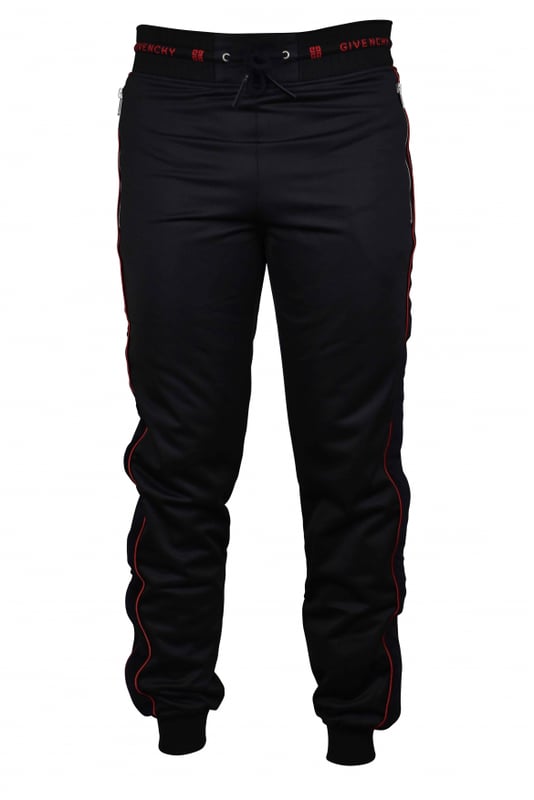 Un jogging de Givenchy.Franja lateral de terciopelo negro con línea roja. Cintura con cordón y puntera de cuero.Logotipo rojo de Givenchy en la cintura. Dos bolsillos con cremallera. Apriete en la parte inferior.Interior de vellón.100% polyester.Made in Italy.