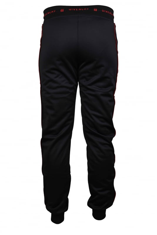 Un jogging de Givenchy.Franja lateral de terciopelo negro con línea roja. Cintura con cordón y puntera de cuero.Logotipo rojo de Givenchy en la cintura. Dos bolsillos con cremallera. Apriete en la parte inferior.Interior de vellón.100% polyester.Made in Italy.