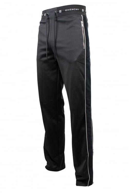 Un jogging de Givenchy.Franja lateral de terciopelo negro con línea blanca. Cordón de ajuste en la cintura.Logotipo blanco de Givenchy en la cintura. Dos bolsillos con cremallera. Cintura recta.Interior de vellón. 100% polyester.Made in Italy.
