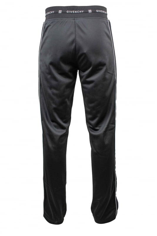 Un jogging de Givenchy.Franja lateral de terciopelo negro con línea blanca. Cordón de ajuste en la cintura.Logotipo blanco de Givenchy en la cintura. Dos bolsillos con cremallera. Cintura recta.Interior de vellón. 100% polyester.Made in Italy.