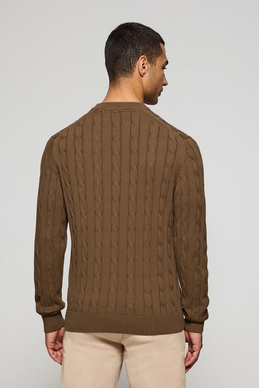 Unser Zopfstrickpullover für Herren ist ein Synonym für Eleganz und Komfort. Sein einzigartiges Flechtmuster verleiht ihm Struktur und Raffinesse, während gerippte Details an Kragen, Ärmeln und Saum für einen guten Sitz und ein raffiniertes Finish sorgen. Das dezente marineblaue Nahtband am Kragen mit Polo Club Logo unterstreicht die Eleganz dieses Modells. Die emblematische Rigby Go Stickerei in Kontrastfarbe auf der Brust unterstreicht seine einzigartige Optik. Ideal für einen eleganten und zeitlosen Look.