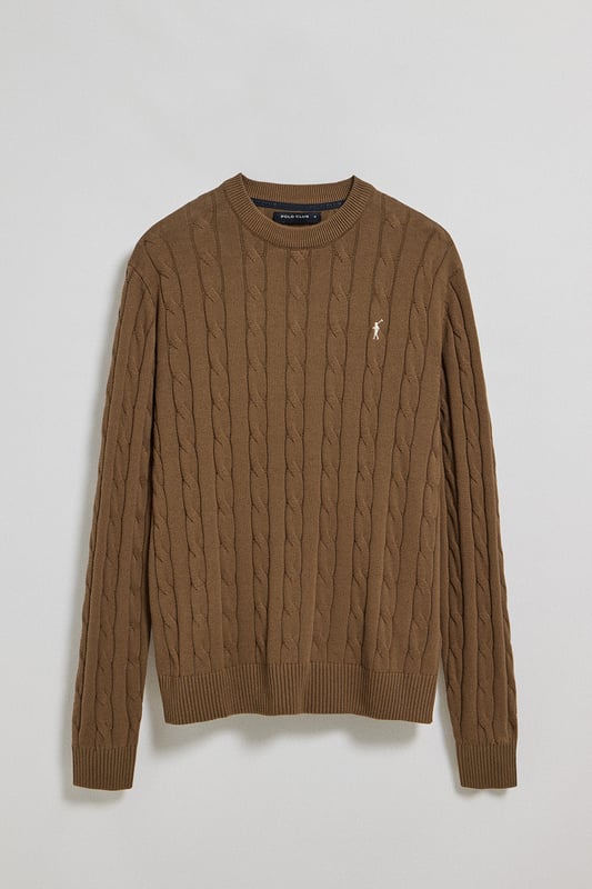 Unser Zopfstrickpullover für Herren ist ein Synonym für Eleganz und Komfort. Sein einzigartiges Flechtmuster verleiht ihm Struktur und Raffinesse, während gerippte Details an Kragen, Ärmeln und Saum für einen guten Sitz und ein raffiniertes Finish sorgen. Das dezente marineblaue Nahtband am Kragen mit Polo Club Logo unterstreicht die Eleganz dieses Modells. Die emblematische Rigby Go Stickerei in Kontrastfarbe auf der Brust unterstreicht seine einzigartige Optik. Ideal für einen eleganten und zeitlosen Look.