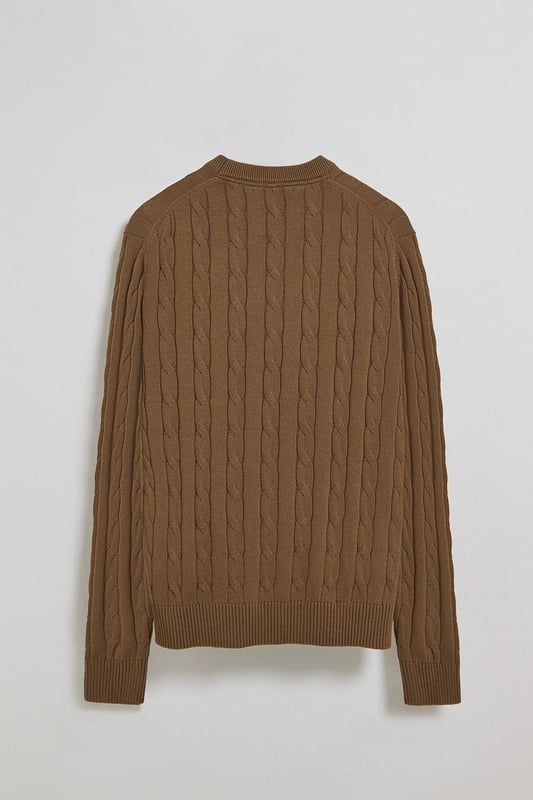 Unser Zopfstrickpullover für Herren ist ein Synonym für Eleganz und Komfort. Sein einzigartiges Flechtmuster verleiht ihm Struktur und Raffinesse, während gerippte Details an Kragen, Ärmeln und Saum für einen guten Sitz und ein raffiniertes Finish sorgen. Das dezente marineblaue Nahtband am Kragen mit Polo Club Logo unterstreicht die Eleganz dieses Modells. Die emblematische Rigby Go Stickerei in Kontrastfarbe auf der Brust unterstreicht seine einzigartige Optik. Ideal für einen eleganten und zeitlosen Look.