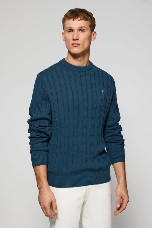 Unser Zopfstrickpullover für Herren ist ein Synonym für Eleganz und Komfort. Sein einzigartiges Flechtmuster verleiht ihm Struktur und Raffinesse, während gerippte Details an Kragen, Ärmeln und Saum für einen guten Sitz und ein raffiniertes Finish sorgen. Das dezente marineblaue Nahtband am Kragen mit Polo Club Logo unterstreicht die Eleganz dieses Modells. Die emblematische Rigby Go Stickerei in Kontrastfarbe auf der Brust unterstreicht seine einzigartige Optik. Ideal für einen eleganten und zeitlosen Look.