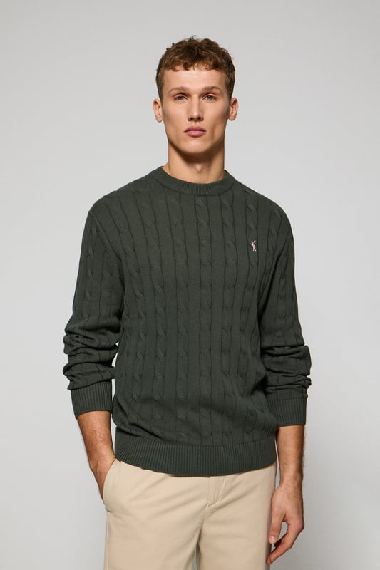 Unser Zopfstrickpullover für Herren ist ein Synonym für Eleganz und Komfort. Sein einzigartiges Flechtmuster verleiht ihm Struktur und Raffinesse, während gerippte Details an Kragen, Ärmeln und Saum für einen guten Sitz und ein raffiniertes Finish sorgen. Das dezente marineblaue Nahtband am Kragen mit Polo Club Logo unterstreicht die Eleganz dieses Modells. Die emblematische Rigby Go Stickerei in Kontrastfarbe auf der Brust unterstreicht seine einzigartige Optik. Ideal für einen eleganten und zeitlosen Look.