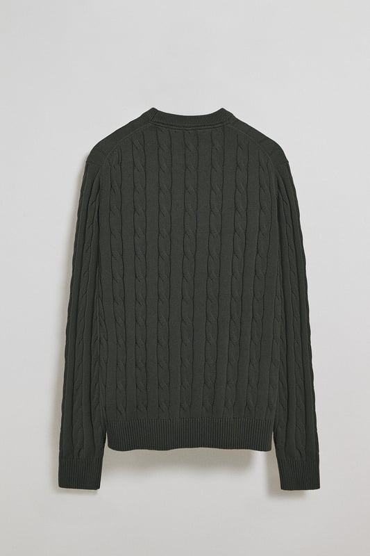 Unser Zopfstrickpullover für Herren ist ein Synonym für Eleganz und Komfort. Sein einzigartiges Flechtmuster verleiht ihm Struktur und Raffinesse, während gerippte Details an Kragen, Ärmeln und Saum für einen guten Sitz und ein raffiniertes Finish sorgen. Das dezente marineblaue Nahtband am Kragen mit Polo Club Logo unterstreicht die Eleganz dieses Modells. Die emblematische Rigby Go Stickerei in Kontrastfarbe auf der Brust unterstreicht seine einzigartige Optik. Ideal für einen eleganten und zeitlosen Look.