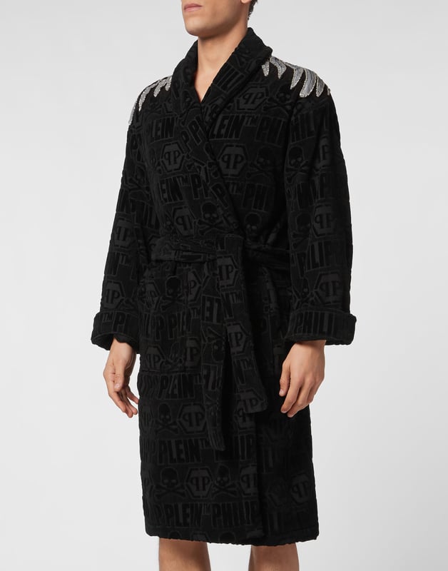 Je ontspant in volle Plein-stijl. Bijvoorbeeld met deze badjas van jacquardgeweven katoenen badstof. Hij heeft een sjaalkraag, een opvallend borduursel op de rug en een strikceintuur aan de voorkant. En twee opgestikte zakken.