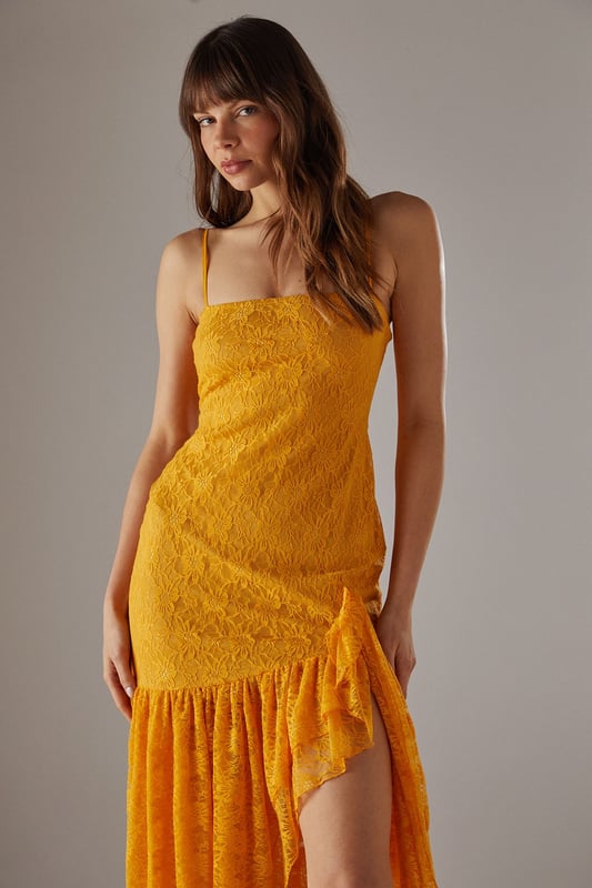 Delicate all-over lace fabric creates a romantic, feminine aesthetic
        Flattering drop waist silhouette with dramatic ruffle detail
        Elegant strappy neckline adds a contemporary touch
        Semi-sheer lace ruffle creates an asymmetric midi hemline
        Lined bodice ensures comfort and coverage where needed
    
    This striking Warehouse midi dress combines sophisticated design with bold femininity. The form-fitting bodice transitions into a playful drop waist ruffle, creating a silhouette that's both flattering and fashion-forward. The delicate lace fabric offers a beautiful textural contrast whilst the asymmetric hemline adds movement and drama. Style with strappy heels and a metallic clutch as shown for evening events, or dress down with leather mules and a tailored blazer for summer garden parties. Perfect for weddings, races or formal occasions where you want to make an impression, this versatile piece can be accessorised with statement jewellery for additional glamour or kept minimal to let the intricate lace detailing take centre stage. The strappy neckline frames the dcolletage beautifully, making this a confident choice for those special moments when you wish to command attention.