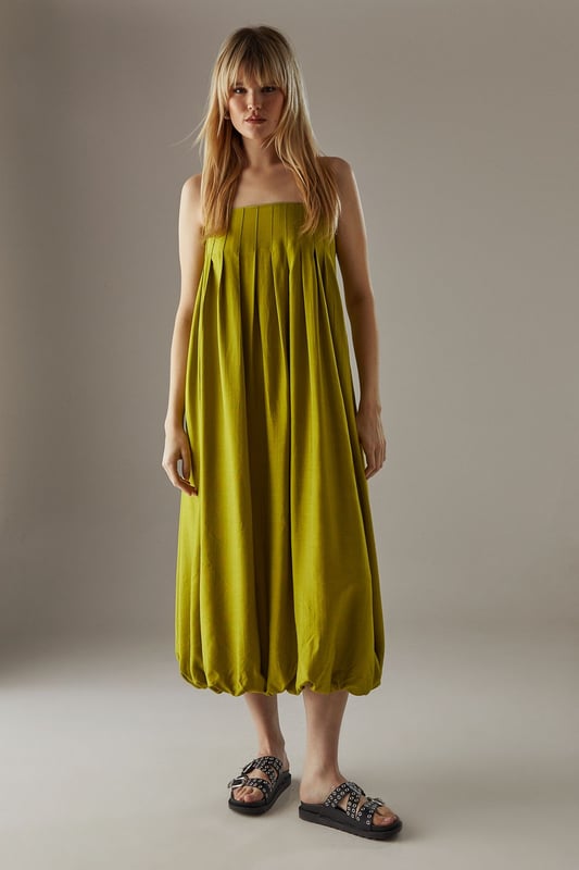 Strappy design with delicate shoulder straps
        Seam detail on bodice creating a pleated effect
        Bubble hem for a playful silhouette
        Midi length for versatile styling
        Relaxed fit through the body for effortless comfort
    
    This strappy seam detail bubble midi sundress from Warehouse is the epitome of casual chic. Perfect for those laid-back summer days, this dress combines comfort with style. The pleated bodice adds texture and interest, while the bubble hem creates a playful, feminine silhouette. Pair it with flat sandals and a woven tote for a relaxed daytime look, or dress it up with wedges and statement earrings for an alfresco dinner. The versatile midi length makes it suitable for various occasions, from family gatherings to casual brunches with friends. Layer with a denim jacket for cooler evenings or style with a wide-brimmed hat for a touch of glamour at outdoor events. This dress is a wardrobe essential that effortlessly transitions from day to night, embodying the confident and edgy spirit of the Warehouse brand.