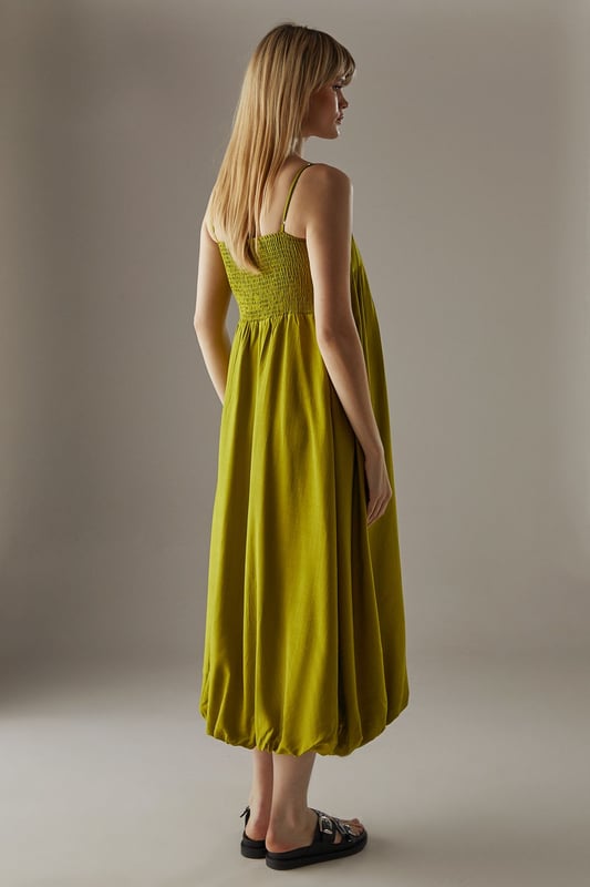 Strappy design with delicate shoulder straps
        Seam detail on bodice creating a pleated effect
        Bubble hem for a playful silhouette
        Midi length for versatile styling
        Relaxed fit through the body for effortless comfort
    
    This strappy seam detail bubble midi sundress from Warehouse is the epitome of casual chic. Perfect for those laid-back summer days, this dress combines comfort with style. The pleated bodice adds texture and interest, while the bubble hem creates a playful, feminine silhouette. Pair it with flat sandals and a woven tote for a relaxed daytime look, or dress it up with wedges and statement earrings for an alfresco dinner. The versatile midi length makes it suitable for various occasions, from family gatherings to casual brunches with friends. Layer with a denim jacket for cooler evenings or style with a wide-brimmed hat for a touch of glamour at outdoor events. This dress is a wardrobe essential that effortlessly transitions from day to night, embodying the confident and edgy spirit of the Warehouse brand.