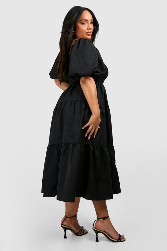 Tiered and ruched design for a flattering silhouette
        Square neckline adds a touch of elegance
        Voluminous puff sleeves create a dramatic look
        Midi length offers versatile styling options
        Smocked bodice ensures a comfortable fit
    
    Make a statement in this eye-catching tiered and ruched smock dress from Boohoo. Perfect for the fashion-forward woman who loves to embrace current trends, this dress combines comfort with style. The square neckline and puff sleeves add a touch of romance, while the tiered skirt creates movement and dimension. Ideal for casual events or family gatherings, this dress can be easily dressed up or down. Pair it with strappy sandals and statement earrings for a daytime look, or switch to heeled mules and a clutch bag for evening drinks. The midi length offers coverage whilst still allowing you to show off your favourite footwear. Whether you're heading to a garden party or a casual dinner date, this versatile dress will ensure you're always on-trend and feeling confident.