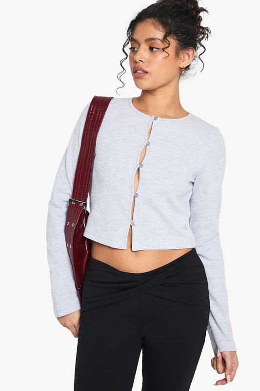 Textured waffle-knit fabric for added visual interest
        Cropped length perfect for high-waisted bottoms
        Scoop neckline for a flattering silhouette
        Button-front closure for adjustable styling
        Long sleeves ideal for layering or solo wear
    
    Embrace casual chic with this versatile waffle-knit top from Boohoo. The cropped silhouette and scoop neckline create a flattering frame, while the button-front detail adds a touch of intrigue. Perfect for those laid-back days, pair it with high-waisted jeans and trainers for a coffee run, or dress it up with a midi skirt and ankle boots for a family gathering. The textured fabric adds depth to your ensemble, making it an ideal choice for transitional weather. Layer it under a denim jacket for extra warmth, or wear it solo on warmer days. This top effortlessly bridges the gap between comfort and style, making it a must-have addition to your casual wardrobe. Whether you're running errands or meeting friends for a casual lunch, this top will keep you looking effortlessly put-together.
