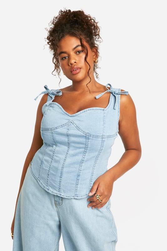 Corset-style denim top with structured panelling
        Sweetheart neckline for a feminine touch
        Adjustable bow-tie shoulder straps
        Exposed back zip for easy wear
        Versatile design suitable for various body types
    
    Embrace your curves with this chic plus-size denim corset top from Boohoo. The structured panelling creates a flattering silhouette, while the sweetheart neckline adds a touch of romance. The adjustable bow-tie straps allow for a customised fit and lend a playful element to the design. Perfect for casual outings, this top pairs brilliantly with wide-leg jeans for a coordinated denim look, or with a flowing skirt for a balanced ensemble. Layer it under a lightweight cardigan for cooler evenings or wear it solo to showcase its unique details. Ideal for family gatherings or brunches with friends, this versatile piece can be dressed up with statement earrings and wedges or kept casual with trainers and a denim jacket. The exposed back zip ensures easy dressing, making this corset top a practical yet stylish addition to your wardrobe.