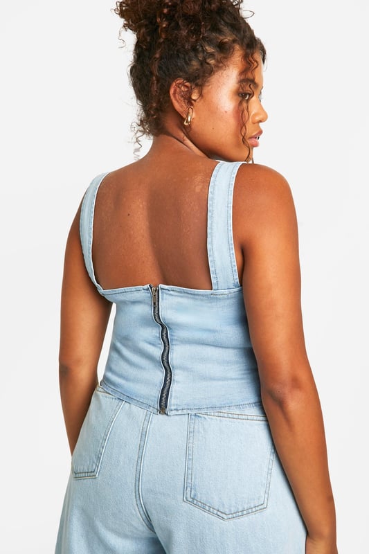 Corset-style denim top with structured panelling
        Sweetheart neckline for a feminine touch
        Adjustable bow-tie shoulder straps
        Exposed back zip for easy wear
        Versatile design suitable for various body types
    
    Embrace your curves with this chic plus-size denim corset top from Boohoo. The structured panelling creates a flattering silhouette, while the sweetheart neckline adds a touch of romance. The adjustable bow-tie straps allow for a customised fit and lend a playful element to the design. Perfect for casual outings, this top pairs brilliantly with wide-leg jeans for a coordinated denim look, or with a flowing skirt for a balanced ensemble. Layer it under a lightweight cardigan for cooler evenings or wear it solo to showcase its unique details. Ideal for family gatherings or brunches with friends, this versatile piece can be dressed up with statement earrings and wedges or kept casual with trainers and a denim jacket. The exposed back zip ensures easy dressing, making this corset top a practical yet stylish addition to your wardrobe.