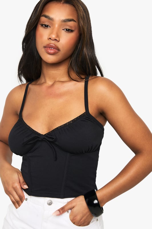 Cotton Lace Trim Tie Front Corset Top Corset-inspired design with lace trim detailing
Adjustable spaghetti straps for a customised fit
Sweetheart neckline accentuates the dcolletage
Figure-hugging silhouette for a flattering shape
Versatile piece suitable for layering or wearing alone
Embrace your inner fashionista with this chic cotton corset top from Boohoo. Perfect for the style-savvy woman in her early twenties, this piece effortlessly combines trendy design with comfort. The lace trim adds a touch of femininity, while the corset-inspired structure creates a flattering silhouette. Pair it with high-waisted white shorts and trainers for a casual daytime look, or dress it up with a sleek midi skirt and heels for evening drinks with friends. The adjustable straps ensure a perfect fit, making it ideal for various body types. Whether you're heading to a family barbecue or a casual catch-up with mates, this versatile top will keep you looking on-trend and feeling confident. Layer it under a blazer for a more polished ensemble, or wear it solo on warmer days. With its blend of cotton and elastane, it offers both comfort and style, embodying Boohoo's commitment to inclusive, value-driven fashion.