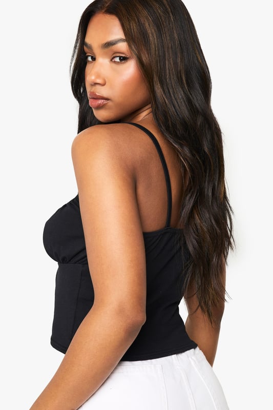 Cotton Lace Trim Tie Front Corset Top Corset-inspired design with lace trim detailing
Adjustable spaghetti straps for a customised fit
Sweetheart neckline accentuates the dcolletage
Figure-hugging silhouette for a flattering shape
Versatile piece suitable for layering or wearing alone
Embrace your inner fashionista with this chic cotton corset top from Boohoo. Perfect for the style-savvy woman in her early twenties, this piece effortlessly combines trendy design with comfort. The lace trim adds a touch of femininity, while the corset-inspired structure creates a flattering silhouette. Pair it with high-waisted white shorts and trainers for a casual daytime look, or dress it up with a sleek midi skirt and heels for evening drinks with friends. The adjustable straps ensure a perfect fit, making it ideal for various body types. Whether you're heading to a family barbecue or a casual catch-up with mates, this versatile top will keep you looking on-trend and feeling confident. Layer it under a blazer for a more polished ensemble, or wear it solo on warmer days. With its blend of cotton and elastane, it offers both comfort and style, embodying Boohoo's commitment to inclusive, value-driven fashion.