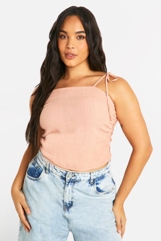 Ruched detailing for a flattering silhouette
        Adjustable tie straps for a customised fit
        Square neckline adds a modern touch
        Cropped length perfect for high-waisted bottoms
        Linen-look fabric for a breezy, summery feel
    
    Embrace effortless style with this versatile plus-size top from Boohoo. The ruched detailing and square neckline create a figure-flattering look, while the adjustable tie straps allow for a personalised fit. Perfect for casual outings, this top pairs beautifully with high-waisted jeans or a flowing maxi skirt. The linen-look fabric offers a lightweight, breathable option for warm days, making it ideal for family gatherings or leisurely brunches with friends. Style it with wide-leg trousers and sandals for a chic daytime ensemble, or dress it up with a statement necklace and wedges for evening drinks. This adaptable piece is sure to become a staple in your summer wardrobe, offering both comfort and style for various casual occasions.