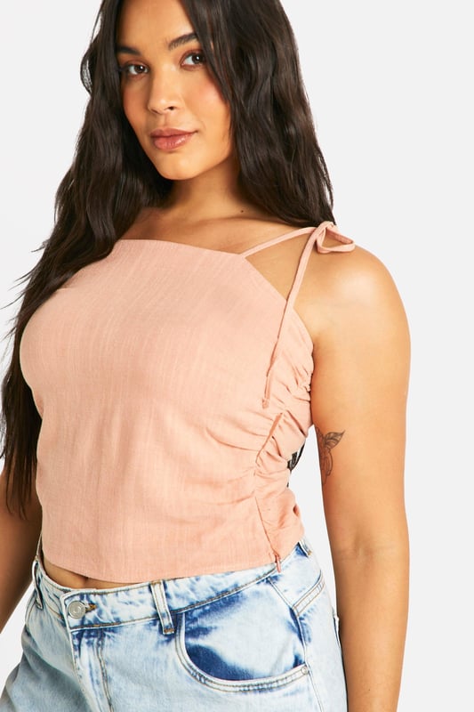Ruched detailing for a flattering silhouette
        Adjustable tie straps for a customised fit
        Square neckline adds a modern touch
        Cropped length perfect for high-waisted bottoms
        Linen-look fabric for a breezy, summery feel
    
    Embrace effortless style with this versatile plus-size top from Boohoo. The ruched detailing and square neckline create a figure-flattering look, while the adjustable tie straps allow for a personalised fit. Perfect for casual outings, this top pairs beautifully with high-waisted jeans or a flowing maxi skirt. The linen-look fabric offers a lightweight, breathable option for warm days, making it ideal for family gatherings or leisurely brunches with friends. Style it with wide-leg trousers and sandals for a chic daytime ensemble, or dress it up with a statement necklace and wedges for evening drinks. This adaptable piece is sure to become a staple in your summer wardrobe, offering both comfort and style for various casual occasions.