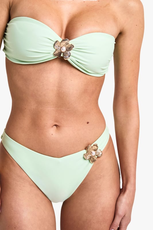 Strapless bandeau-style top with gathered centre detail
        Decorative pearl-like floral embellishment on top and bottoms
        High-cut bikini bottoms for a leg-lengthening effect
        Smooth, stretchy fabric for comfort and fit
        Coordinated two-piece design for a cohesive beach look
    
    Make waves this summer in this eye-catching bikini set that combines style and sophistication. The strapless bandeau top offers support and freedom of movement, perfect for sunbathing or a game of beach volleyball. The high-cut bottoms create the illusion of longer legs, ideal for strutting along the shoreline. The standout feature is the delicate pearl-like floral embellishment, adding a touch of glamour to your beachwear ensemble. Pair with oversized sunglasses and a wide-brimmed hat for ultimate poolside chic, or throw on a sheer kaftan and wedge sandals for a stylish transition to beachside cocktails. Whether you're jetting off to a tropical paradise or enjoying a staycation by the lido, this versatile bikini set will ensure you look and feel fabulous under the sun.