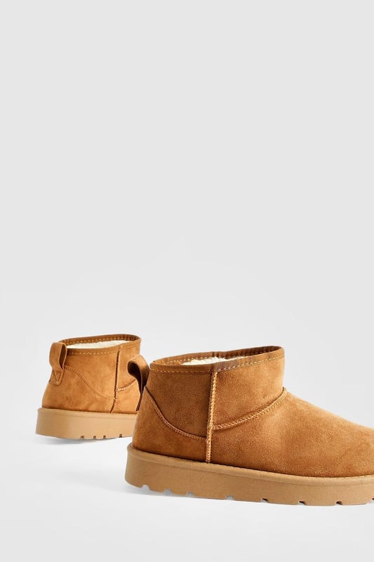 Ultra mini design for a trendy, compact silhouette
        Cosy synthetic suede upper for warmth and comfort
        Slip-on style for easy wear
        Durable synthetic outer sole for traction
        Versatile ankle height suitable for various outfits
    
    Step into comfort and style with these ultra mini cosy boots from Boohoo. Perfect for the fashion-forward woman who values both trend and practicality, these boots offer a snug fit that's ideal for chilly days. The ankle-height design makes them incredibly versatile, pairing effortlessly with everything from skinny jeans to midi skirts. For a laid-back look, team them with oversized knitwear and leggings, or dress them up with a flowy dress and tights for casual outings. These boots are a must-have for family gatherings, coffee dates, or weekend shopping trips. Their compact size makes them an excellent choice for travel, easily fitting into your luggage without sacrificing style. Embrace the cosy-chic trend and make these ultra mini boots your go-to footwear for comfortable, on-trend casual wear.