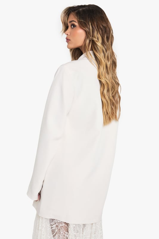 Oversized blazer with structured shoulder pads for a bold silhouette
        Deep plunging neckline creates a dramatic, contemporary look
        Relaxed fit design offers comfortable movement and versatile styling options
        Classic collared detail with notched lapels for timeless appeal
        Functional front pockets add practical detail to this statement piece
    
    Make a striking impression with this Boohoo oversized blazer, designed to command attention with its deep neckline and structured shoulder pads. The relaxed fit creates an effortlessly chic silhouette that works brilliantly for evening occasions. Style it as seen with a delicate lace skirt for an intriguing contrast between tailoring and femininity, or pair with slim-fit trousers and heels for a sophisticated night out look. For an edgier ensemble, throw it over a bodysuit with statement jewellery and your favourite clutch bag. This versatile blazer transitions seamlessly from drinks with friends to club nights, offering that perfect balance of comfort and head-turning style that's essential for your going-out wardrobe. Add sleek sunglasses and minimalist accessories to complete this contemporary urban nightlife look.