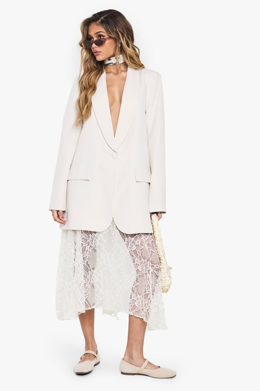 Oversized blazer with structured shoulder pads for a bold silhouette
        Deep plunging neckline creates a dramatic, contemporary look
        Relaxed fit design offers comfortable movement and versatile styling options
        Classic collared detail with notched lapels for timeless appeal
        Functional front pockets add practical detail to this statement piece
    
    Make a striking impression with this Boohoo oversized blazer, designed to command attention with its deep neckline and structured shoulder pads. The relaxed fit creates an effortlessly chic silhouette that works brilliantly for evening occasions. Style it as seen with a delicate lace skirt for an intriguing contrast between tailoring and femininity, or pair with slim-fit trousers and heels for a sophisticated night out look. For an edgier ensemble, throw it over a bodysuit with statement jewellery and your favourite clutch bag. This versatile blazer transitions seamlessly from drinks with friends to club nights, offering that perfect balance of comfort and head-turning style that's essential for your going-out wardrobe. Add sleek sunglasses and minimalist accessories to complete this contemporary urban nightlife look.