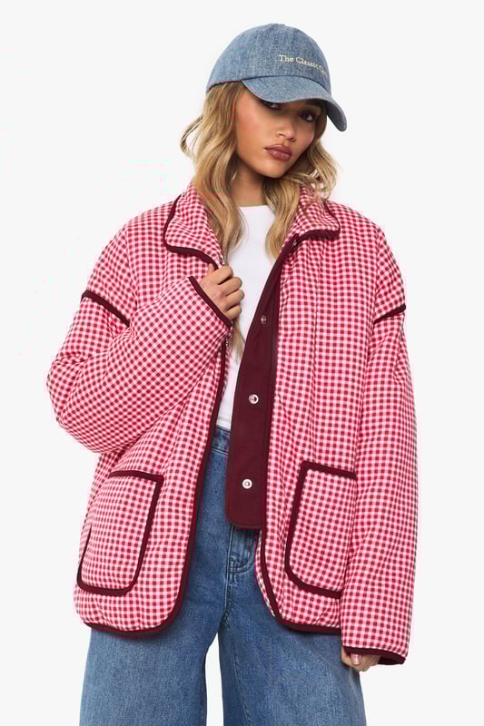 Oversized jacket featuring eye-catching gingham print with contrasting trim detailing
        Roomy front pockets with decorative piping for both style and functionality
        Relaxed drop-shoulder design offering a contemporary silhouette
        Button-through front closure for easy wear and versatility
        High collar that can be worn up or down depending on your style preference
    
    Make a bold statement with this striking oversized jacket that combines retro charm with modern styling. The distinctive gingham pattern creates visual interest while the generous cut ensures comfort for everyday wear. Style it as seen with wide-leg jeans and a simple white tee for an effortlessly cool daytime look, or layer over a fitted dress for a playful contrast in proportions. Perfect for casual outings, weekend brunches or family gatherings, this jacket works brilliantly with trainers for a relaxed vibe. For cooler days, add a beanie and chunky scarf to complete the look. The versatile design transitions seamlessly from autumn strolls to spring picnics, making it a wardrobe staple that will refresh your casual collection with its distinctive character and relaxed appeal.