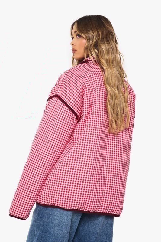 Oversized jacket featuring eye-catching gingham print with contrasting trim detailing
        Roomy front pockets with decorative piping for both style and functionality
        Relaxed drop-shoulder design offering a contemporary silhouette
        Button-through front closure for easy wear and versatility
        High collar that can be worn up or down depending on your style preference
    
    Make a bold statement with this striking oversized jacket that combines retro charm with modern styling. The distinctive gingham pattern creates visual interest while the generous cut ensures comfort for everyday wear. Style it as seen with wide-leg jeans and a simple white tee for an effortlessly cool daytime look, or layer over a fitted dress for a playful contrast in proportions. Perfect for casual outings, weekend brunches or family gatherings, this jacket works brilliantly with trainers for a relaxed vibe. For cooler days, add a beanie and chunky scarf to complete the look. The versatile design transitions seamlessly from autumn strolls to spring picnics, making it a wardrobe staple that will refresh your casual collection with its distinctive character and relaxed appeal.