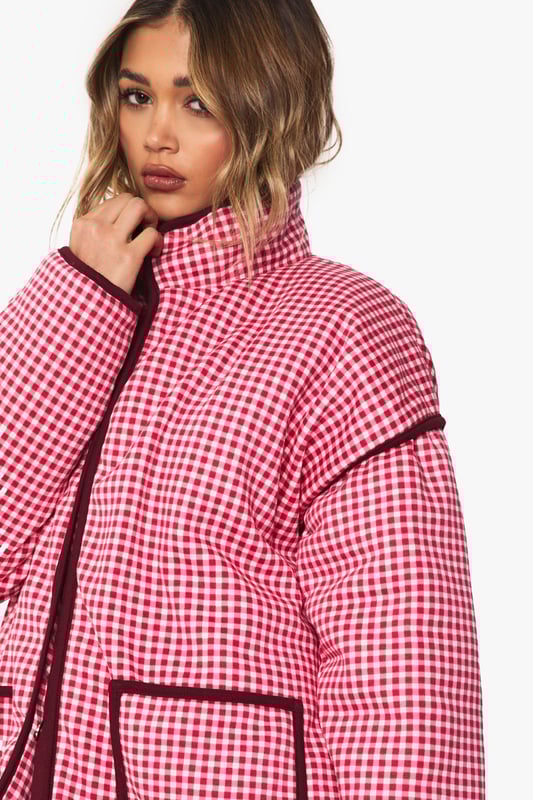 Oversized jacket featuring eye-catching gingham print with contrasting trim detailing
        Roomy front pockets with decorative piping for both style and functionality
        Relaxed drop-shoulder design offering a contemporary silhouette
        Button-through front closure for easy wear and versatility
        High collar that can be worn up or down depending on your style preference
    
    Make a bold statement with this striking oversized jacket that combines retro charm with modern styling. The distinctive gingham pattern creates visual interest while the generous cut ensures comfort for everyday wear. Style it as seen with wide-leg jeans and a simple white tee for an effortlessly cool daytime look, or layer over a fitted dress for a playful contrast in proportions. Perfect for casual outings, weekend brunches or family gatherings, this jacket works brilliantly with trainers for a relaxed vibe. For cooler days, add a beanie and chunky scarf to complete the look. The versatile design transitions seamlessly from autumn strolls to spring picnics, making it a wardrobe staple that will refresh your casual collection with its distinctive character and relaxed appeal.