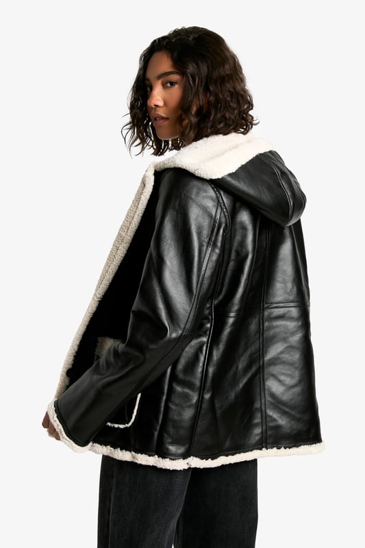 Hooded design for added warmth and style
        Cosy borg lining for superior insulation
        Contrasting trim detailing for a chic look
        Practical front pockets for convenience
        Versatile button-up front closure
    
    Make a bold statement this season with our Tall Kunstleder-Mantel mit Borg-Futter und Kapuze. This striking coat combines edgy style with practical comfort, perfect for the fashion-forward Boohoo girl. The contrasting borg lining not only adds a trendy touch but also ensures you stay snug during chilly days. Style it over a simple white tee and wide-leg trousers for a casual yet put-together look, as seen on our model. For a night out with friends, pair it with a mini dress and chunky boots to create an outfit that's sure to turn heads. The versatile nature of this coat makes it suitable for various casual occasions, from impromptu coffee dates to laid-back family gatherings. Its tall fit ensures a flattering silhouette for those blessed with height, while the practical hood and pockets add functionality to its fashionable design. Embrace the latest trends and stay cosy in style with this must-have piece from Boohoo.
