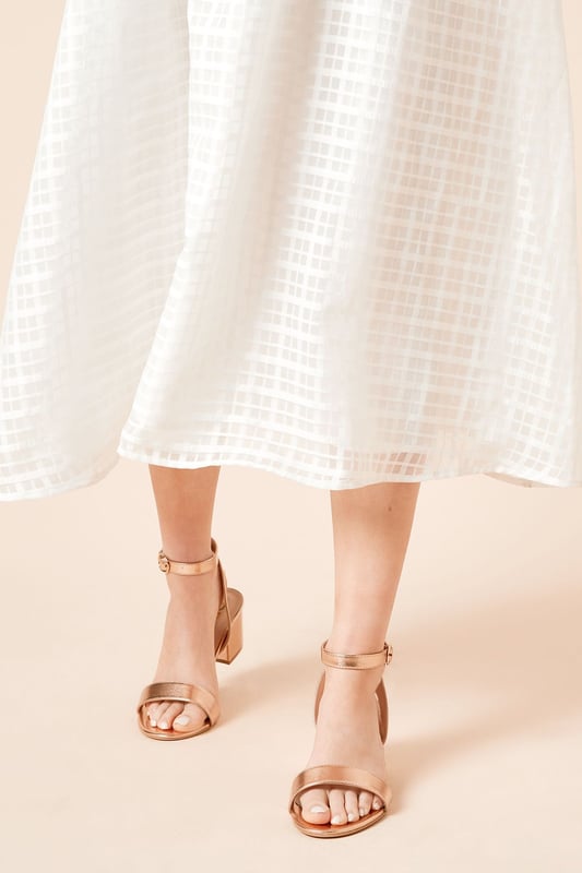 Wide fit design offers a comfortable and accommodating fit
Barely-there strappy silhouette with minimalist appeal
Mid block heel provides a modest lift and walkable height
Faux leather upper exudes a look and feel
Ankle strap with buckle closure ensures a secure fit

These versatile sandals are perfect for casual daytime outings or relaxed evening affairs. Pair them with a flowy midi dress or cropped trousers for a chic, on-trend look that transitions seamlessly from brunch with friends to an evening baby shower. The neutral hue complements a variety of ensembles, allowing you to showcase your personal style effortlessly.