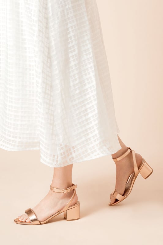 Wide fit design offers a comfortable and accommodating fit
Barely-there strappy silhouette with minimalist appeal
Mid block heel provides a modest lift and walkable height
Faux leather upper exudes a look and feel
Ankle strap with buckle closure ensures a secure fit

These versatile sandals are perfect for casual daytime outings or relaxed evening affairs. Pair them with a flowy midi dress or cropped trousers for a chic, on-trend look that transitions seamlessly from brunch with friends to an evening baby shower. The neutral hue complements a variety of ensembles, allowing you to showcase your personal style effortlessly.