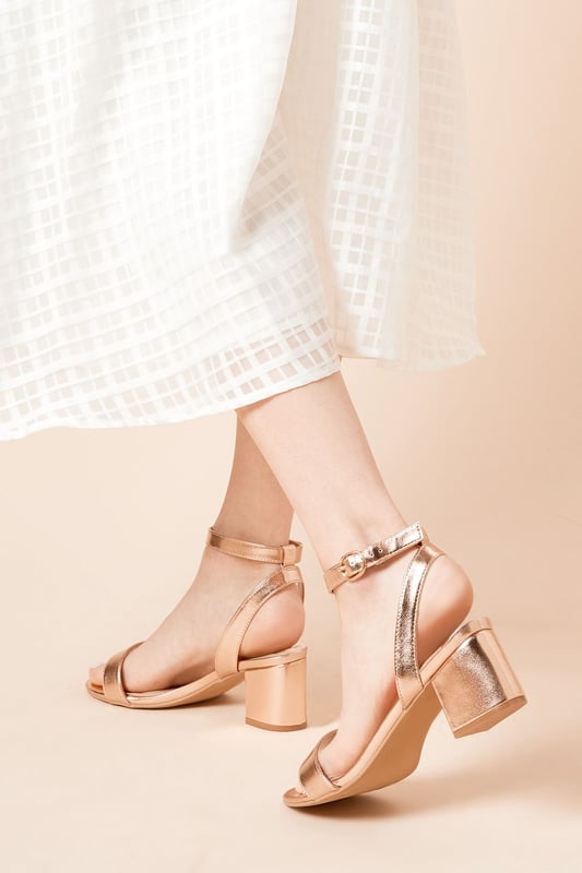 Wide fit design offers a comfortable and accommodating fit
Barely-there strappy silhouette with minimalist appeal
Mid block heel provides a modest lift and walkable height
Faux leather upper exudes a look and feel
Ankle strap with buckle closure ensures a secure fit

These versatile sandals are perfect for casual daytime outings or relaxed evening affairs. Pair them with a flowy midi dress or cropped trousers for a chic, on-trend look that transitions seamlessly from brunch with friends to an evening baby shower. The neutral hue complements a variety of ensembles, allowing you to showcase your personal style effortlessly.