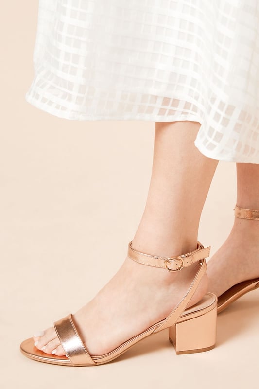 Wide fit design offers a comfortable and accommodating fit
Barely-there strappy silhouette with minimalist appeal
Mid block heel provides a modest lift and walkable height
Faux leather upper exudes a look and feel
Ankle strap with buckle closure ensures a secure fit

These versatile sandals are perfect for casual daytime outings or relaxed evening affairs. Pair them with a flowy midi dress or cropped trousers for a chic, on-trend look that transitions seamlessly from brunch with friends to an evening baby shower. The neutral hue complements a variety of ensembles, allowing you to showcase your personal style effortlessly.