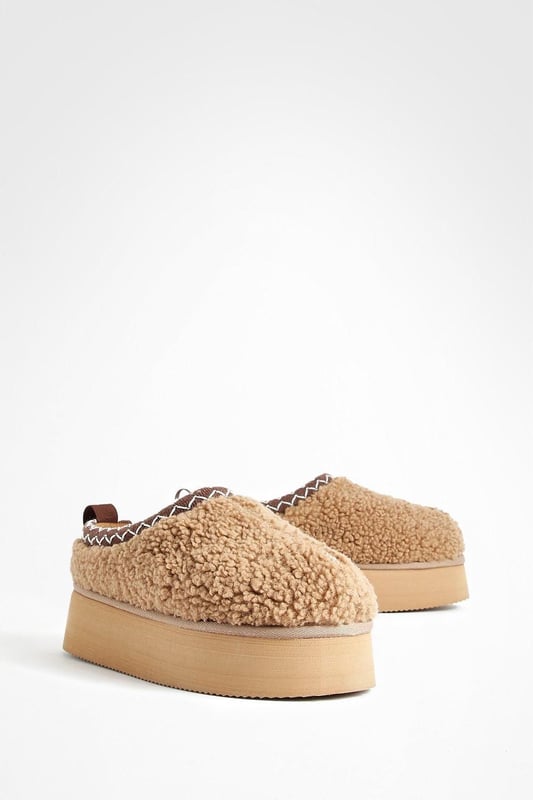Cosy borg material for ultimate comfort
        Stylish platform design with a flat heel (0-2cm)
        Embroidered detailing adds a unique touch
        Slip-on style for easy wear
        Versatile mule silhouette for indoor and outdoor use
    
    Step into comfort and style with these eye-catching borg mules. The plush texture of the borg material envelops your feet in warmth, making them perfect for lounging at home or running quick errands. The platform design adds a trendy edge, while the flat heel ensures all-day comfort. The embroidered detailing elevates these mules from simple house shoes to a fashion statement. Pair them with your favourite joggers and an oversized jumper for a cosy day in, or style them with cropped jeans and a chunky knit for casual outings. These versatile slip-ons are ideal for family gatherings, lazy weekends, or any occasion where you want to combine comfort with a touch of flair. The easy slip-on style means you can quickly transition from indoor relaxation to outdoor adventures without missing a beat.