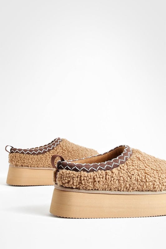 Cosy borg material for ultimate comfort
        Stylish platform design with a flat heel (0-2cm)
        Embroidered detailing adds a unique touch
        Slip-on style for easy wear
        Versatile mule silhouette for indoor and outdoor use
    
    Step into comfort and style with these eye-catching borg mules. The plush texture of the borg material envelops your feet in warmth, making them perfect for lounging at home or running quick errands. The platform design adds a trendy edge, while the flat heel ensures all-day comfort. The embroidered detailing elevates these mules from simple house shoes to a fashion statement. Pair them with your favourite joggers and an oversized jumper for a cosy day in, or style them with cropped jeans and a chunky knit for casual outings. These versatile slip-ons are ideal for family gatherings, lazy weekends, or any occasion where you want to combine comfort with a touch of flair. The easy slip-on style means you can quickly transition from indoor relaxation to outdoor adventures without missing a beat.