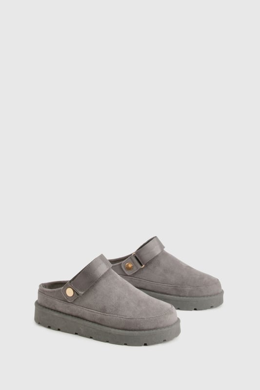Cosy mule design for ultimate comfort
        Flat heel between 0 and 2cm for easy wear
        Soft, plush upper material for a luxurious feel
        Sturdy sole with textured grip for stability
        Decorative button detail adds a stylish touch
    
    Step into a world of comfort and style with these irresistibly cosy mules from Boohoo. Perfect for those lazy days at home or casual outings, these slip-ons offer the ideal blend of comfort and fashion-forward design. The plush upper material envelops your feet in warmth, while the flat heel ensures all-day wearability. Style these versatile mules with your favourite loungewear for a relaxed day in, or pair them with cropped jeans and an oversized jumper for a chic, off-duty look. Whether you're popping to the shops or meeting friends for a casual brunch, these mules will keep you looking effortlessly stylish and feeling utterly comfortable. The subtle button detail adds a touch of elegance, making these the perfect choice for those who appreciate both comfort and understated sophistication in their footwear.