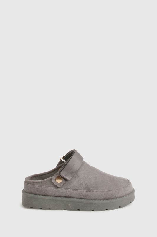 Cosy mule design for ultimate comfort
        Flat heel between 0 and 2cm for easy wear
        Soft, plush upper material for a luxurious feel
        Sturdy sole with textured grip for stability
        Decorative button detail adds a stylish touch
    
    Step into a world of comfort and style with these irresistibly cosy mules from Boohoo. Perfect for those lazy days at home or casual outings, these slip-ons offer the ideal blend of comfort and fashion-forward design. The plush upper material envelops your feet in warmth, while the flat heel ensures all-day wearability. Style these versatile mules with your favourite loungewear for a relaxed day in, or pair them with cropped jeans and an oversized jumper for a chic, off-duty look. Whether you're popping to the shops or meeting friends for a casual brunch, these mules will keep you looking effortlessly stylish and feeling utterly comfortable. The subtle button detail adds a touch of elegance, making these the perfect choice for those who appreciate both comfort and understated sophistication in their footwear.