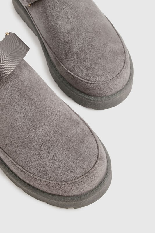 Cosy mule design for ultimate comfort
        Flat heel between 0 and 2cm for easy wear
        Soft, plush upper material for a luxurious feel
        Sturdy sole with textured grip for stability
        Decorative button detail adds a stylish touch
    
    Step into a world of comfort and style with these irresistibly cosy mules from Boohoo. Perfect for those lazy days at home or casual outings, these slip-ons offer the ideal blend of comfort and fashion-forward design. The plush upper material envelops your feet in warmth, while the flat heel ensures all-day wearability. Style these versatile mules with your favourite loungewear for a relaxed day in, or pair them with cropped jeans and an oversized jumper for a chic, off-duty look. Whether you're popping to the shops or meeting friends for a casual brunch, these mules will keep you looking effortlessly stylish and feeling utterly comfortable. The subtle button detail adds a touch of elegance, making these the perfect choice for those who appreciate both comfort and understated sophistication in their footwear.