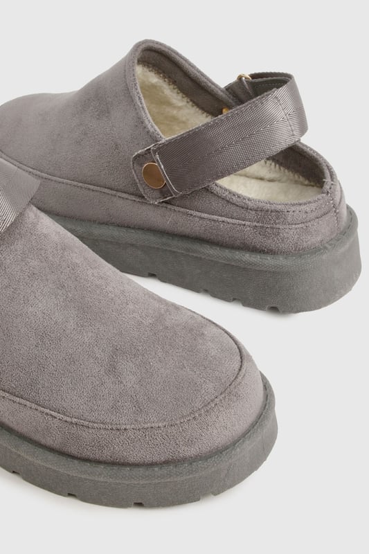 Cosy mule design for ultimate comfort
        Flat heel between 0 and 2cm for easy wear
        Soft, plush upper material for a luxurious feel
        Sturdy sole with textured grip for stability
        Decorative button detail adds a stylish touch
    
    Step into a world of comfort and style with these irresistibly cosy mules from Boohoo. Perfect for those lazy days at home or casual outings, these slip-ons offer the ideal blend of comfort and fashion-forward design. The plush upper material envelops your feet in warmth, while the flat heel ensures all-day wearability. Style these versatile mules with your favourite loungewear for a relaxed day in, or pair them with cropped jeans and an oversized jumper for a chic, off-duty look. Whether you're popping to the shops or meeting friends for a casual brunch, these mules will keep you looking effortlessly stylish and feeling utterly comfortable. The subtle button detail adds a touch of elegance, making these the perfect choice for those who appreciate both comfort and understated sophistication in their footwear.